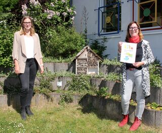 Kindergarten-Leiterin Monika Müller (r.) zeigt Nina Pützer von der Gemeinde Kall stolz das Zertifikat: Der Golbacher Kindergarten ist als erste Einrichtung im Gemeindegebiet Nationalpark-Kita