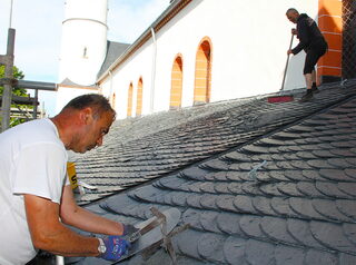 Handwerkskunst und Erfahrung: Dachdecker Ergin Birihci hat mit seinen Kollegen die Dächer gedeckt. Zum Einsatz kam die Altdeutsche Deckung, die als Königsdisziplin der Schieferdeckung gilt.