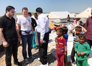 Hilfsgruppen-Aktivist Thomas Tampier (2.v.l.) mit Kindern im Flüchtlingslager in Mossul.