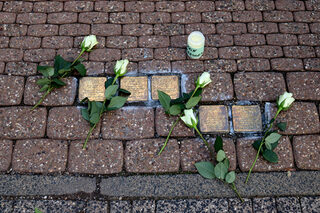 An jedem der 23 Stolpersteine legten die Omas gegen rechts Blumen nieder und zündeten an jedem Stolperstein-Standort eine Kerze an – so wie hier bei den fünf Stolpersteinen der Familien Katz und Roer vor der Kaller Geschäftsstelle der VR-Bank Nordeifel.