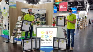 Damian Meiswinkel (Kreis Euskirchen) und Patrick Schmidder (Nordeifel Tourismus GmbH) präsentieren die Urkunden für die ausgezeichneten EifelSpuren.