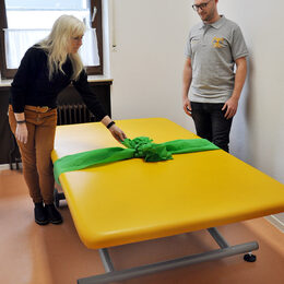 Kita-Leiterin Heidi Zander hatte die Therapie-Liege mit einer großen Schleife dekoriert, bevor sie das Geschenk an den Physiotherapeuten Philipp Hück übergab.