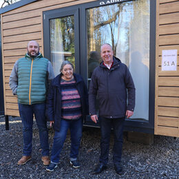 Monika Zahn freut sich über ihr neues Zuhause in einem der zehn Tiny Houses, die die Gemeinde Kall für Flutopfer errichten ließ. Bürgermeister Hermann-Josef Esser (rechts) und Projektleiter Christoph Graf (links) statteten ihr jetzt einen Besuch ab.