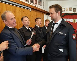 Bürgermeister Hermann-Josef Esser gratuliert Unterbrandmeister Andy Wilms zur Verleihung des silbernen Feuerwehr-Ehrenzeichens. Foto: Reiner Züll