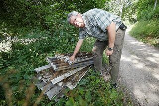 Harald Heinen sichtet den illegal abgelegten Sondermüll am Rande eines Waldweges im Gillesbachtal.