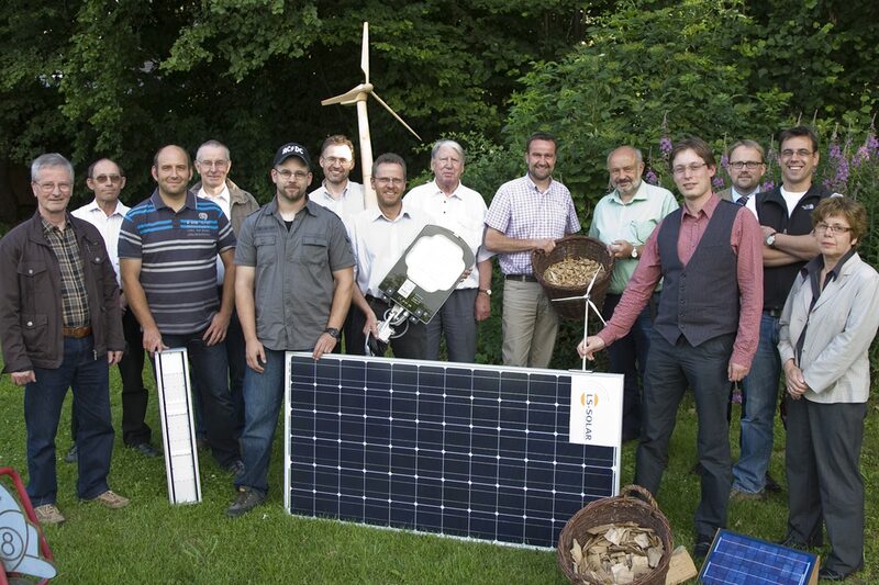 Gruppenfoto Energieteam Kall, mit Solarpanel und Windrad