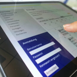 Ein Finger tippt auf ein Tablet mit der Website des Ratsinformationssystems